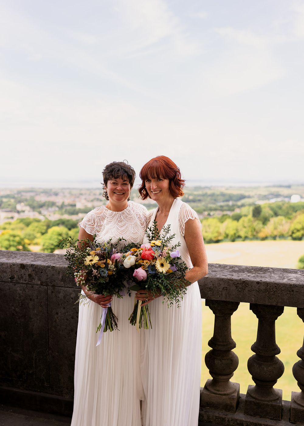 • Inclusive Lancashire wedding photographer capturing a same sex couple laughing together on the viewing gallery at Williamson Park