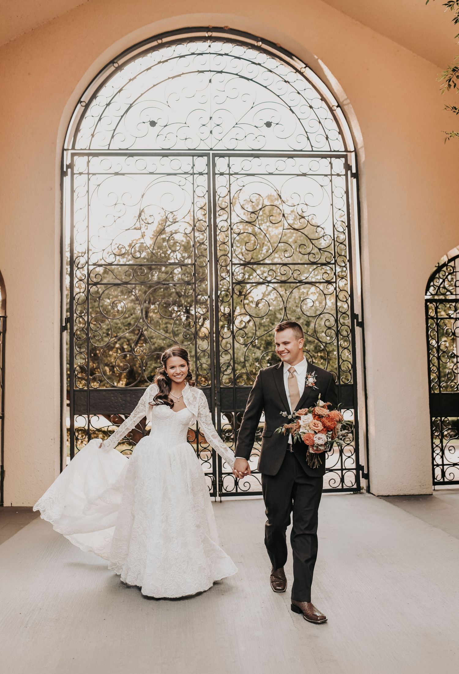 Newly married couple walking through St Ann Catholic Parish courtyard in coppell