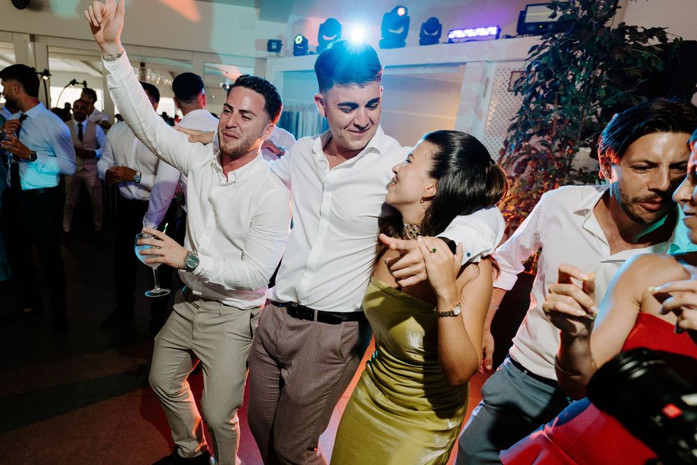 Guests dancing joyfully at a wedding reception party.