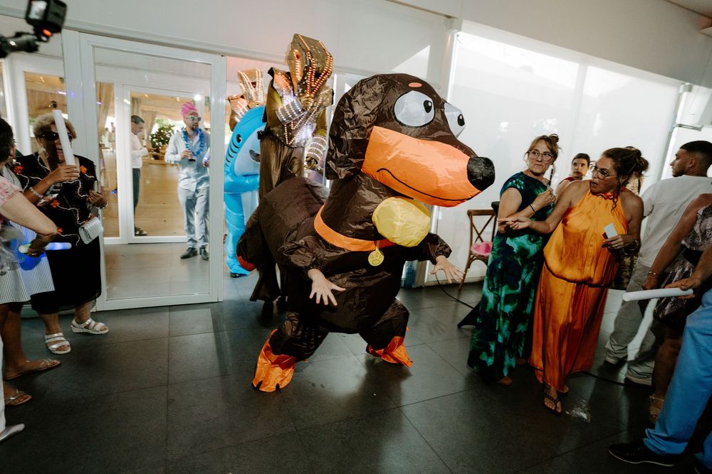 Person in inflatable dog costume entertaining guests at a party.