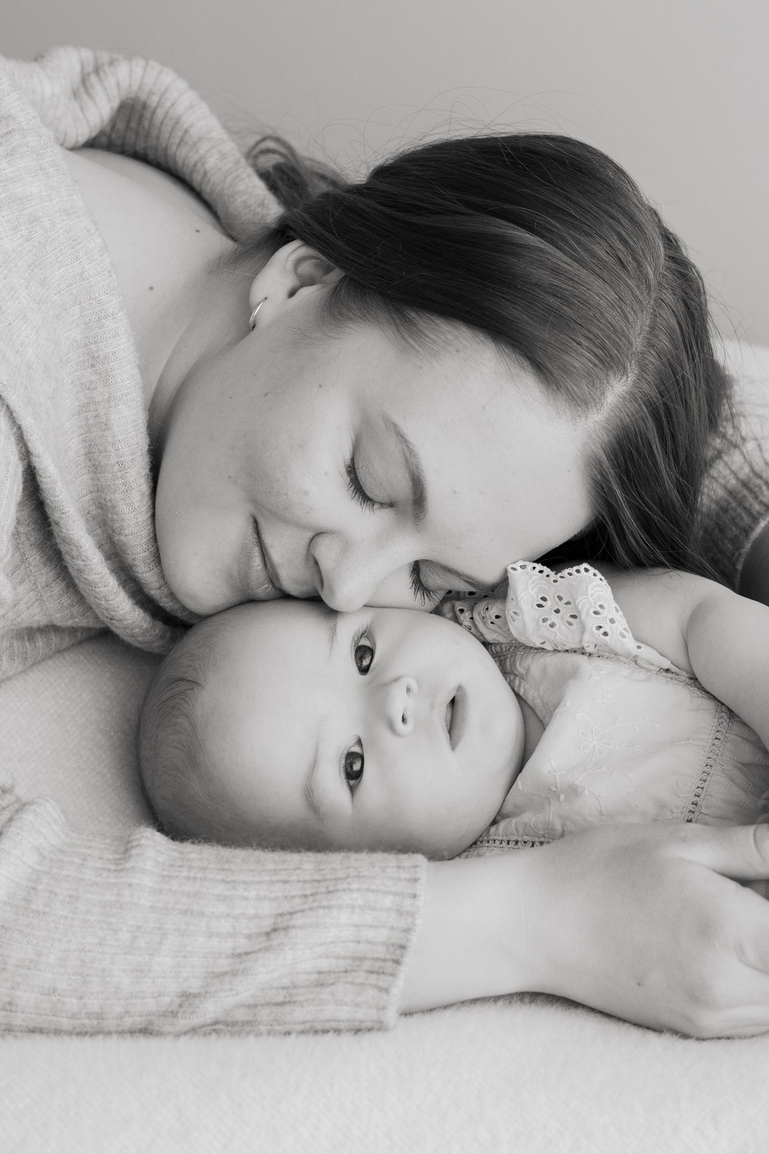 Kuuden kuukauden ikäinen vauva kuvattuna äitinsä syleilyssä.