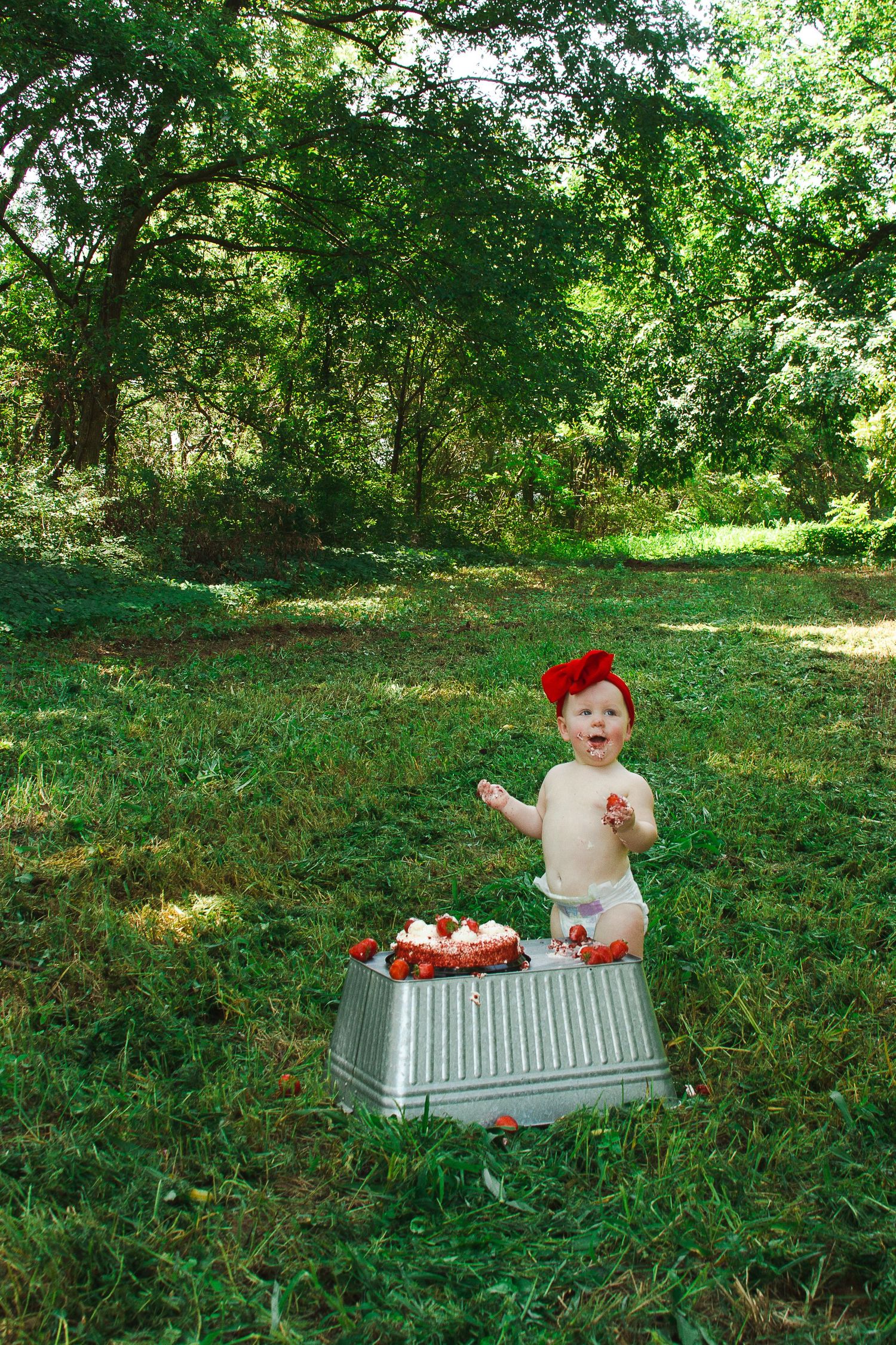 a baby eating strawberries during a 1 year photography session in Manila, Arkansas