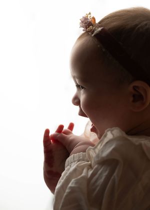 Baby sitting with a stuffed animal during a simple milestone photography session in New Jersey.