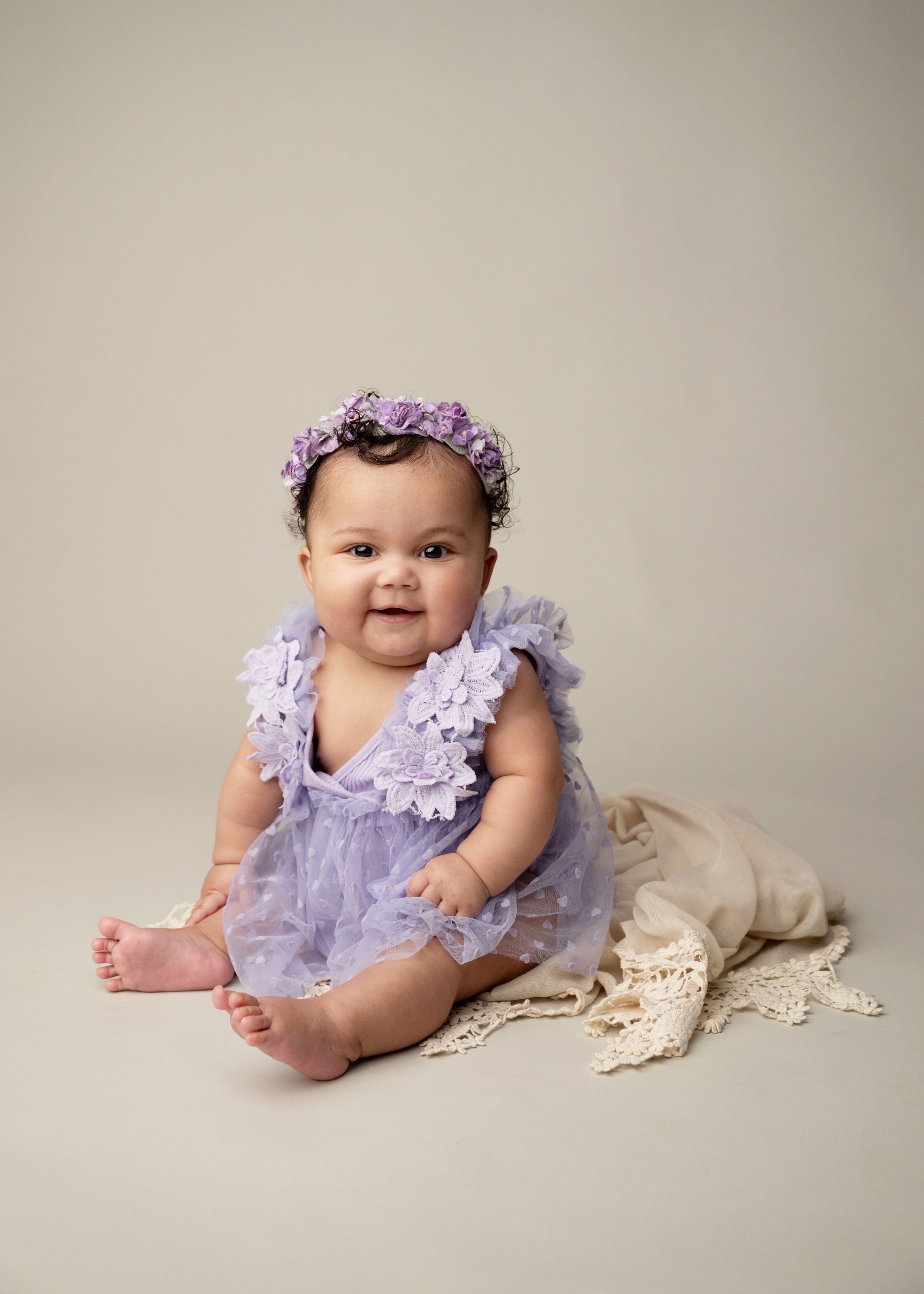 Baby girl sitting for a milestone portrait session in a neutral New Jersey photography studio.