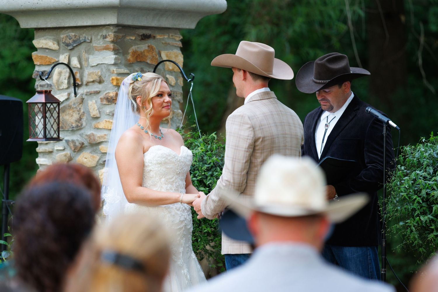 Cowgirl marries her long-time love under a hand-made archway in the rural hills of Missouri at her families horse farm.