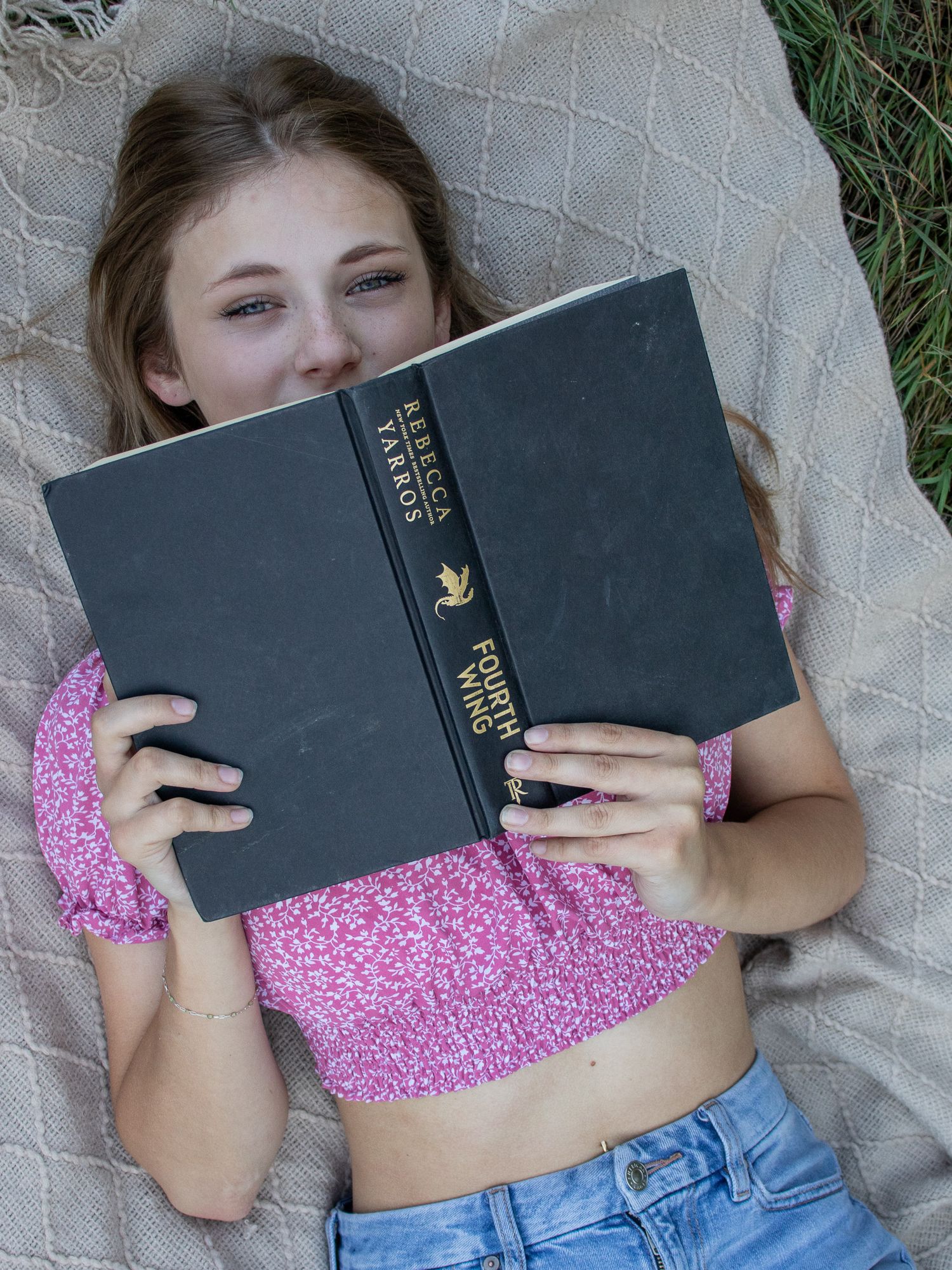 Senior photos - girl reading a book on a blanket in the grass in Strongsville.