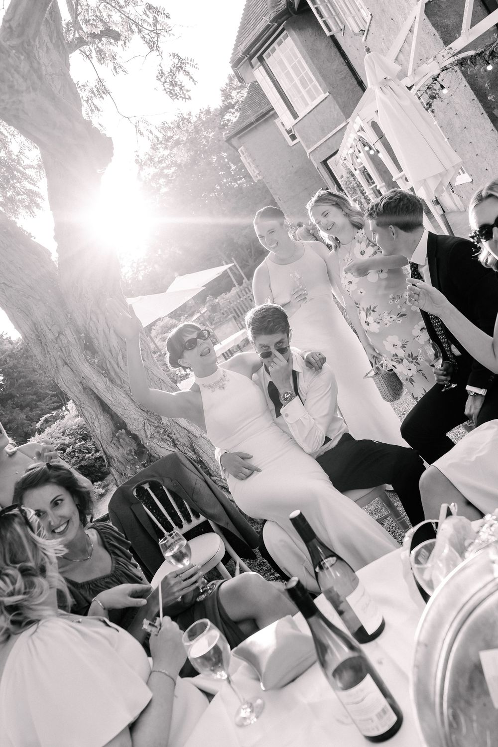 Bride and groom mingling with guests at a sunny outdoor wedding reception.