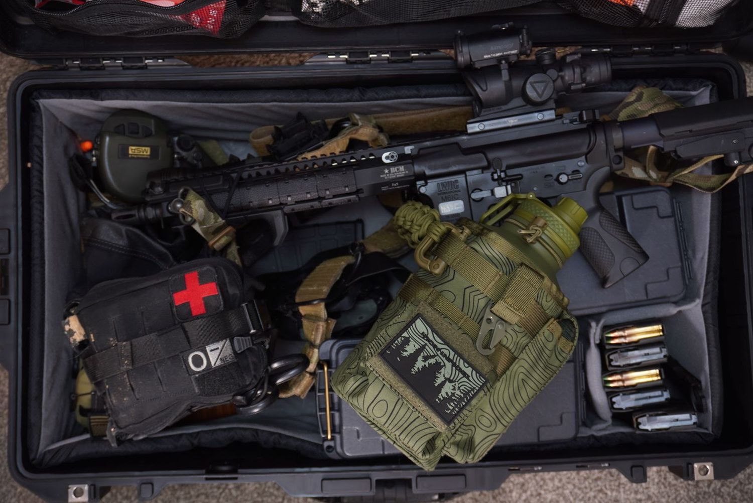 Group of armed individuals in tactical gear participating in outdoor firearms training on a dirt range.
