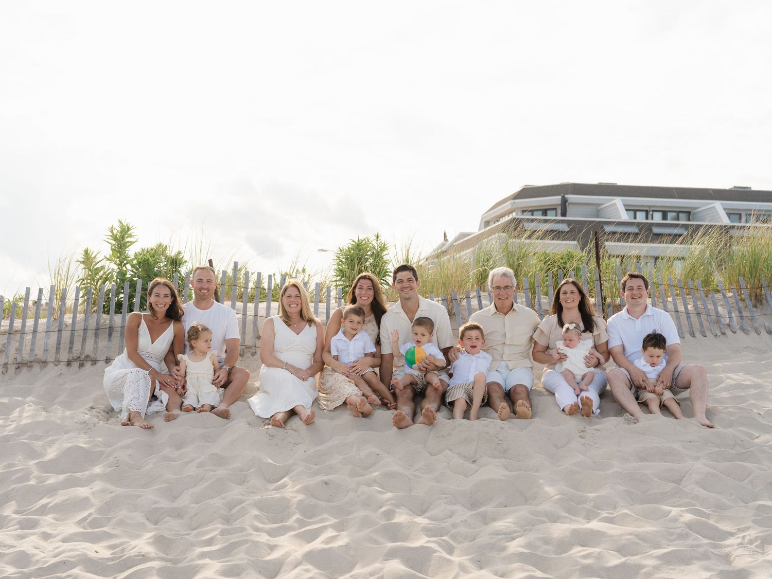 Extended multi-generational family sitting on the sand near the water in Point Pleasant Beach NJ.