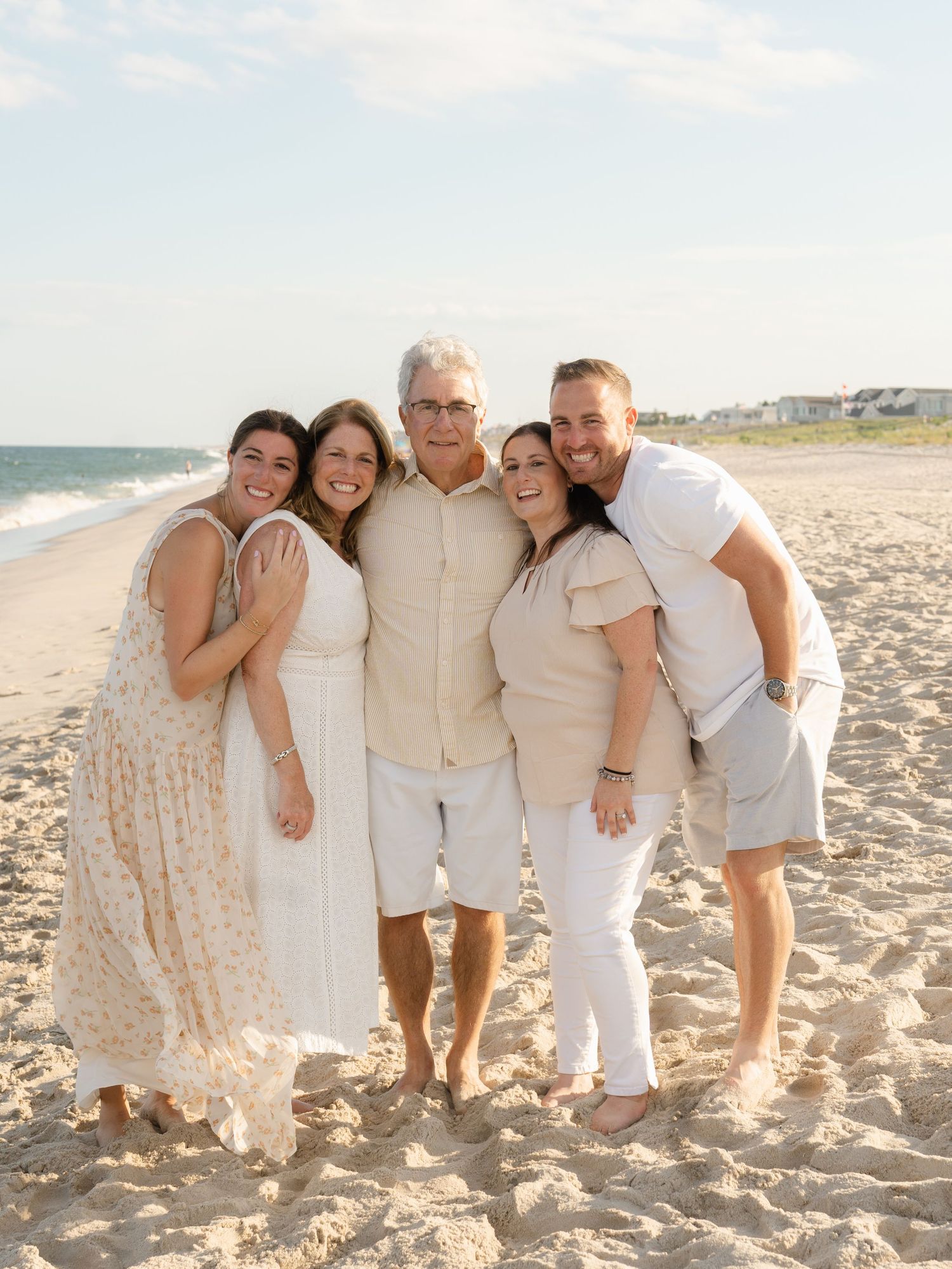 Grandparents with their adult children snuggle close together for a group picture during their family session with Lauren Marie Photography.