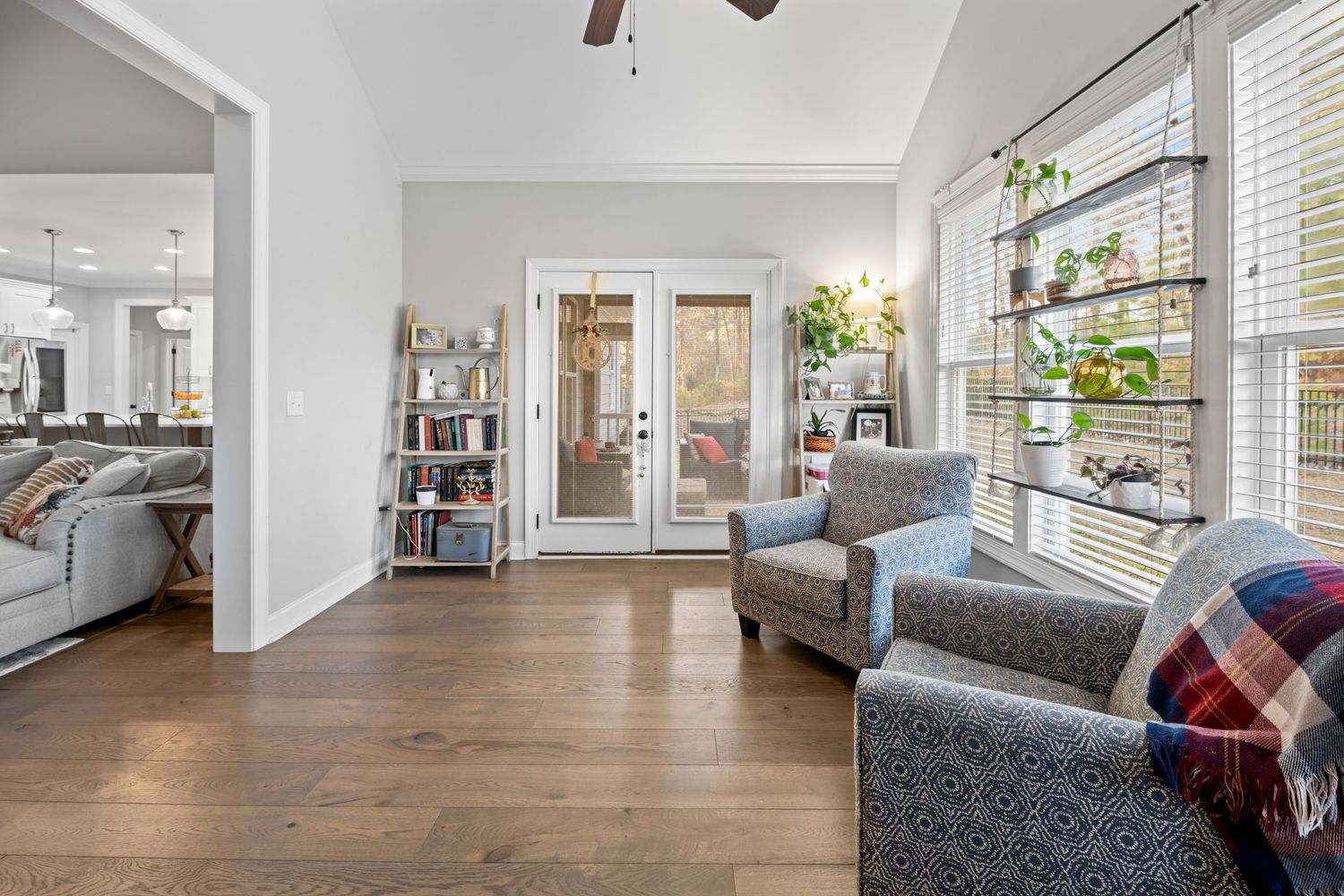 Bright residential living space with hardwood floors and large windows for a real estate listing