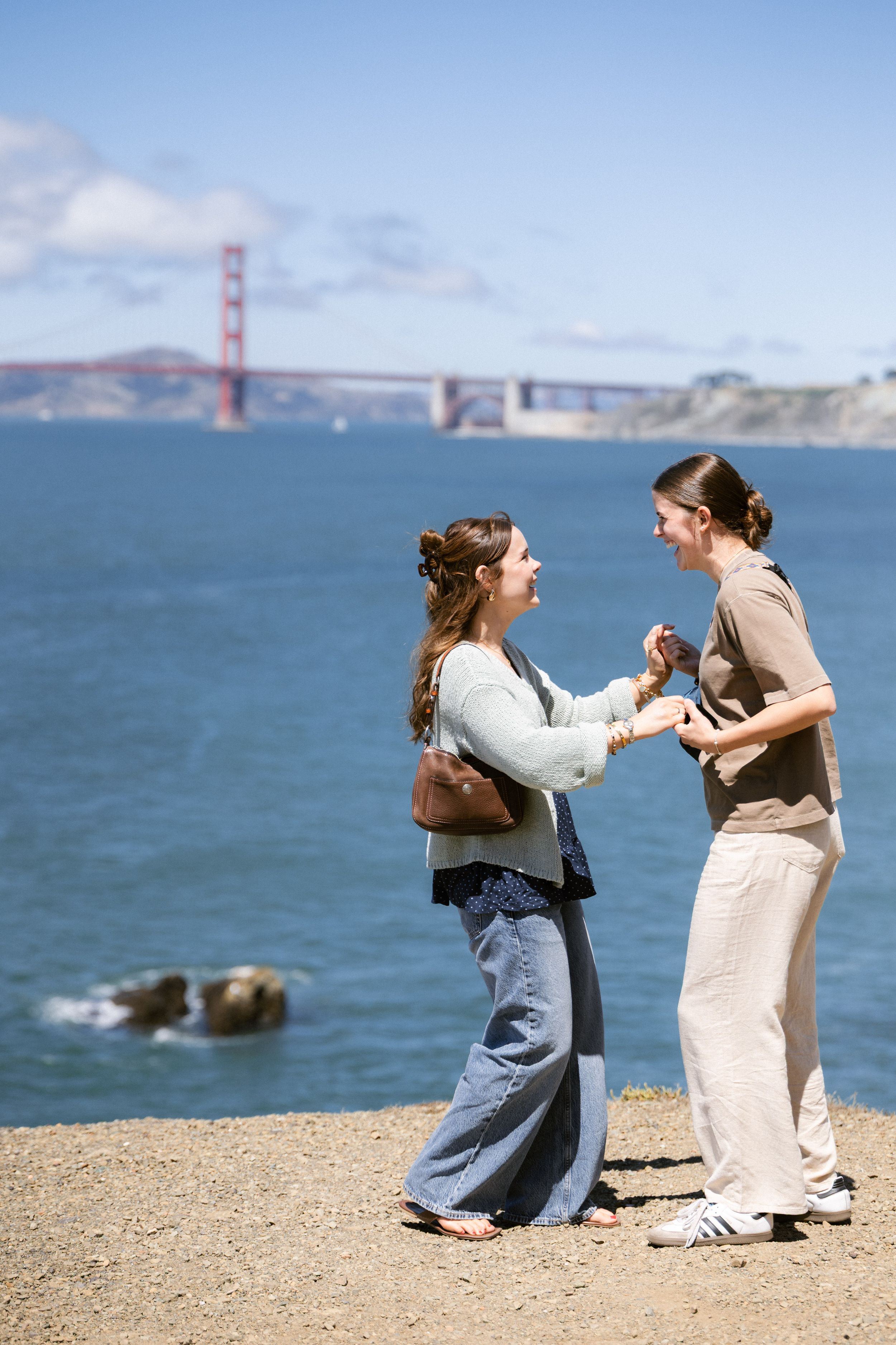 Woman proposing to her partner at Lands End with Golden Gate Bridge