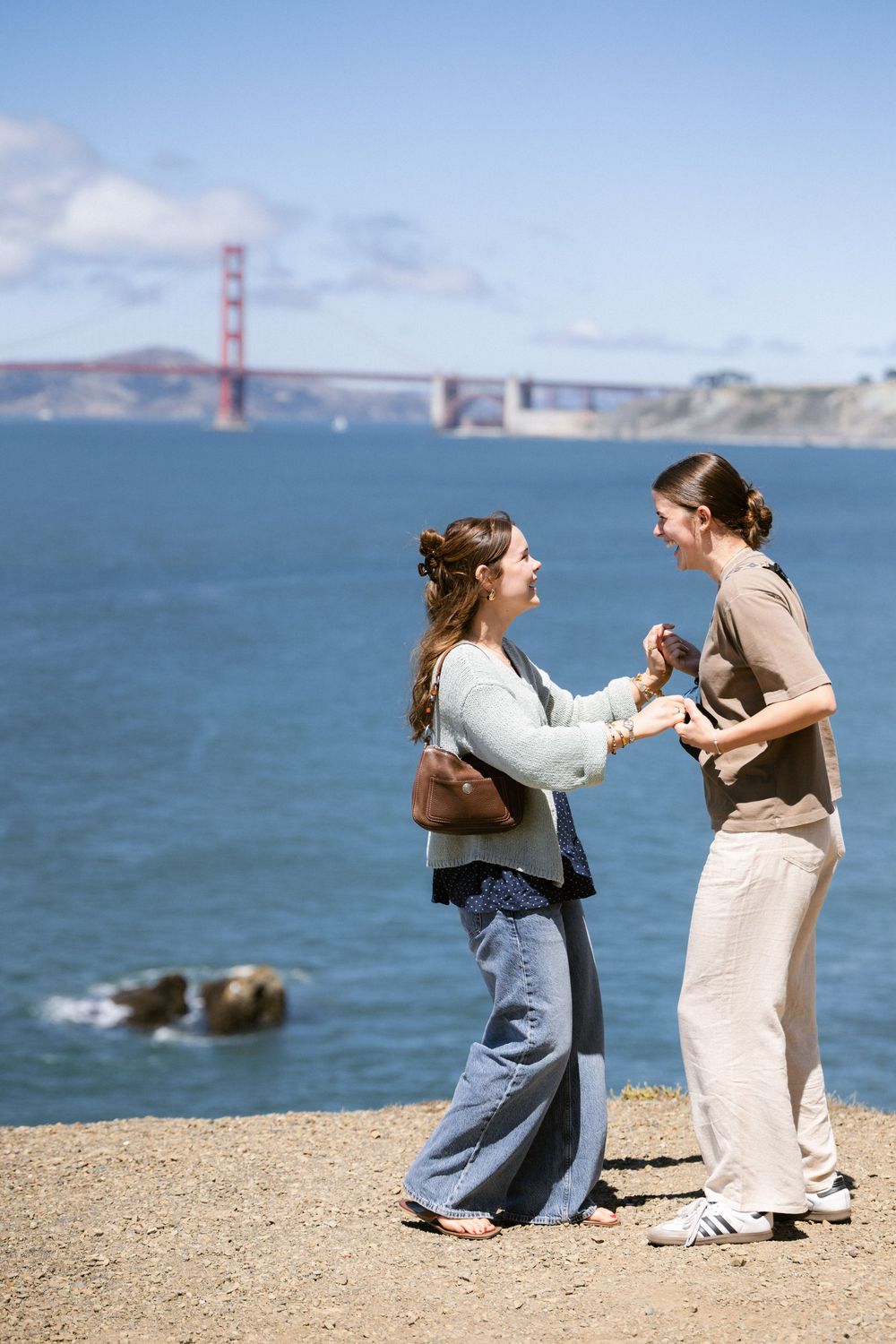 Woman proposing to her partner at Lands End with Golden Gate Bridge