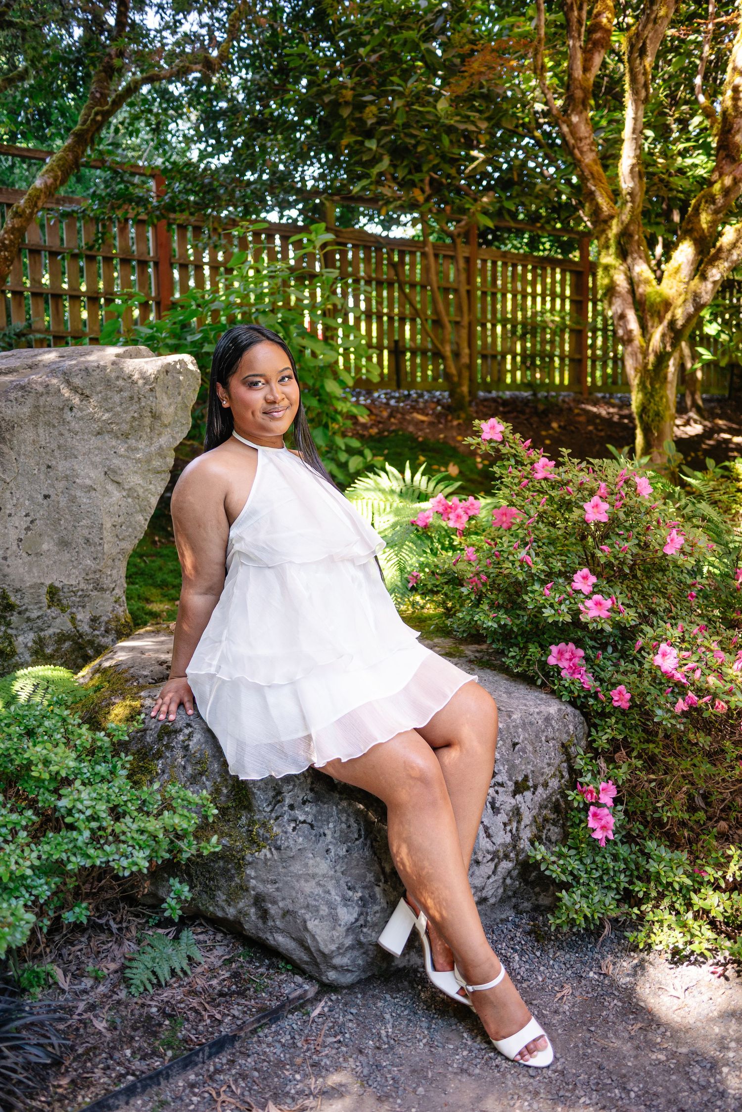 Portrait in a white dress beside pink flowers and greenery at Bellevue Botanical Garden