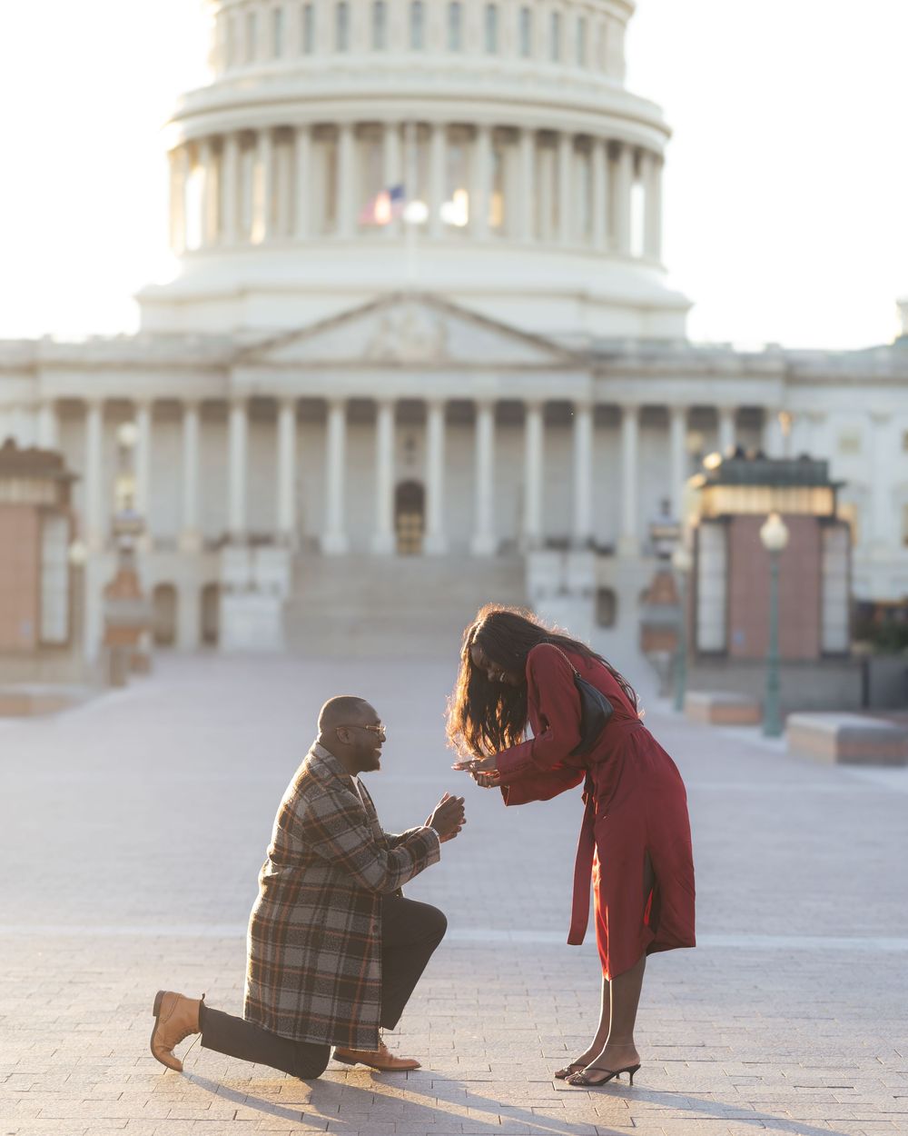 Couple sharing an intimate moment outside the US Capitol Building at sunset.