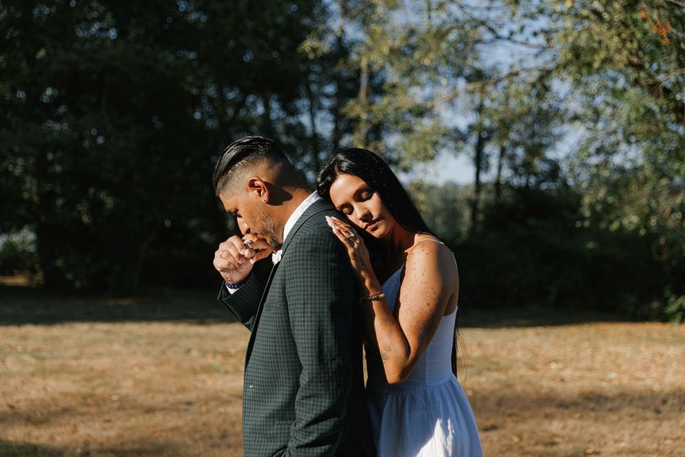 Bride leaning on groom's shoulder during outdoor wedding portrait.