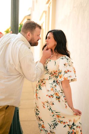 A tender moment shared between a couple against a white wall backdrop.
