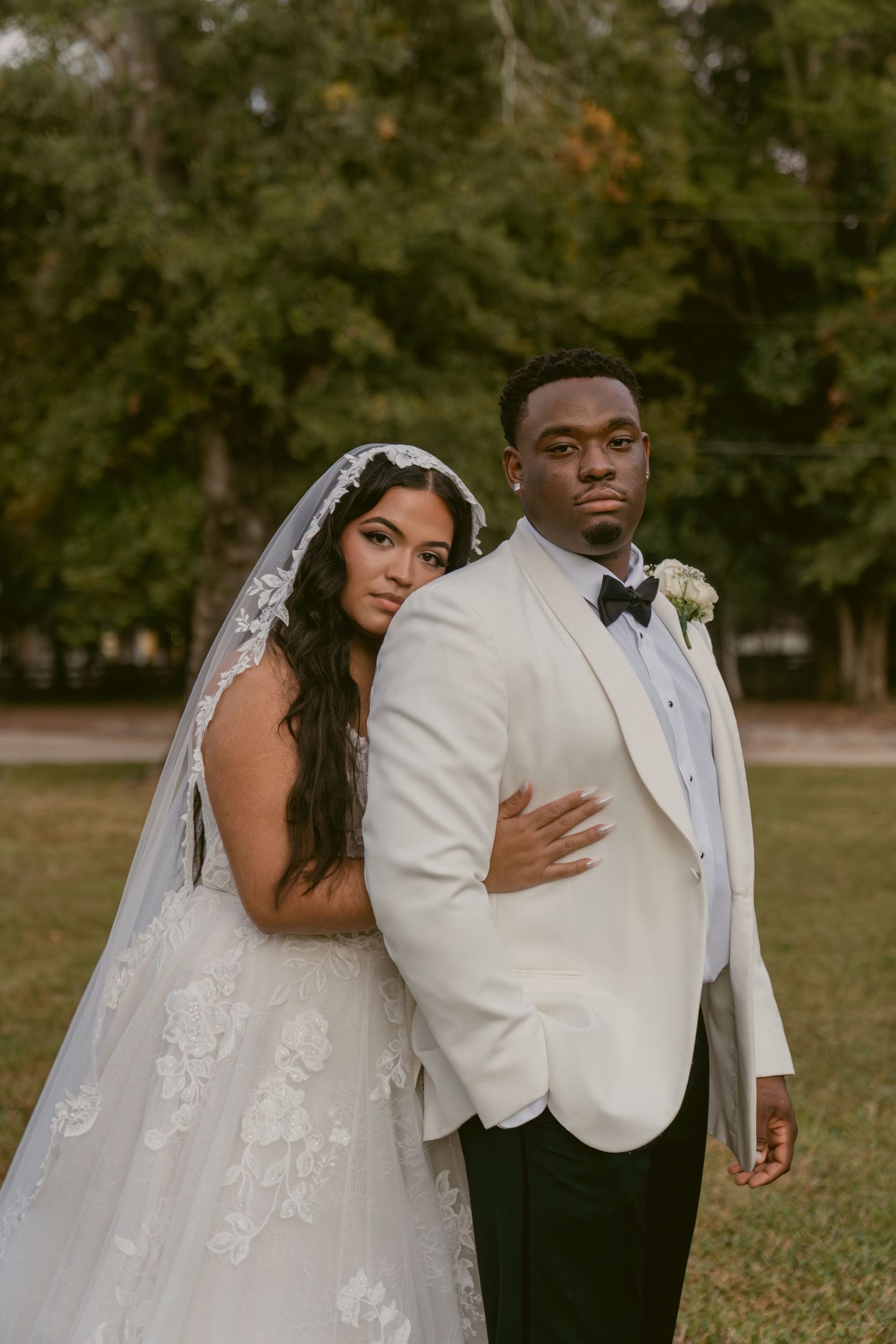 A romantic wedding photo series showing a bride and groom in white attire posing together outdoors in an autumn setting.