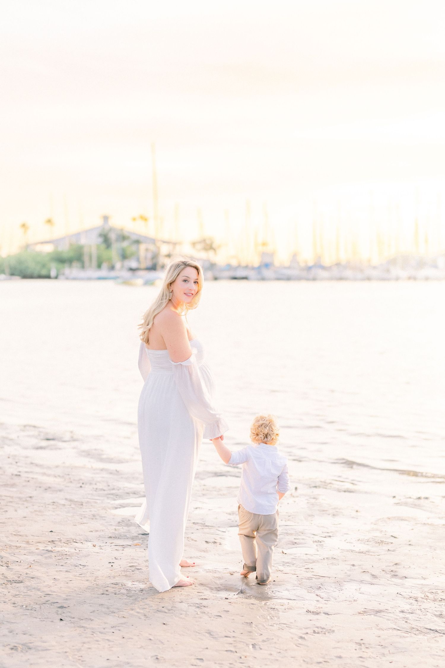 mother expecting a baby posing for their maternity photoshoot at golden hour at the beach in Tampa