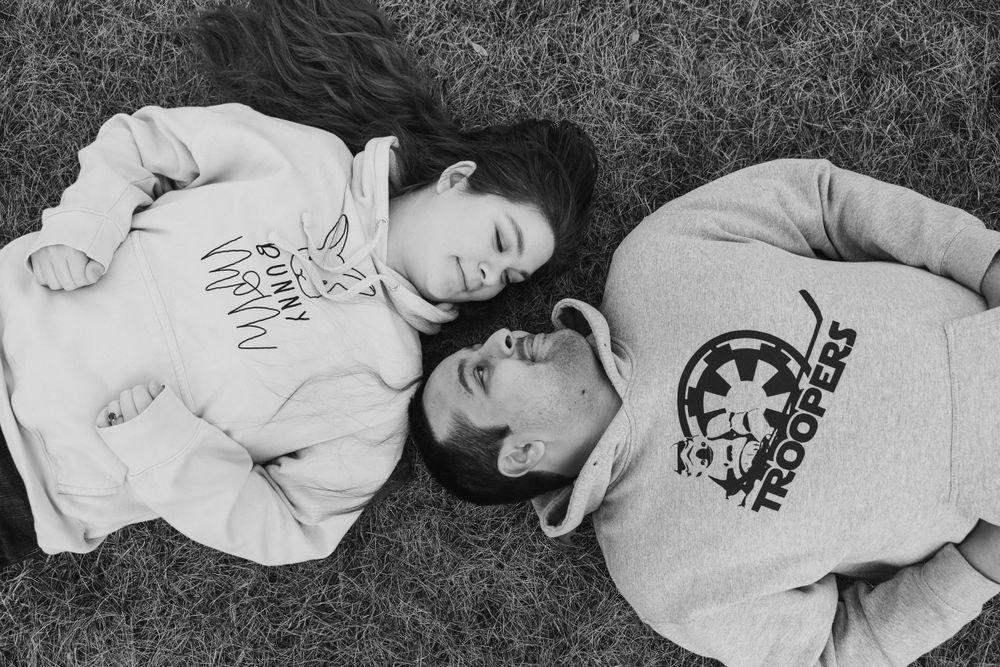 Black and white photo series showing couple lying in grass during casual photoshoot.
