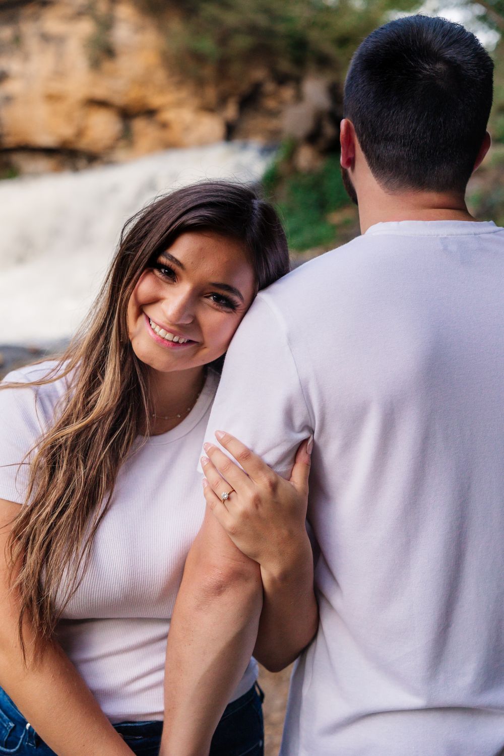 Happy moment captured between couple at scenic waterfall location.