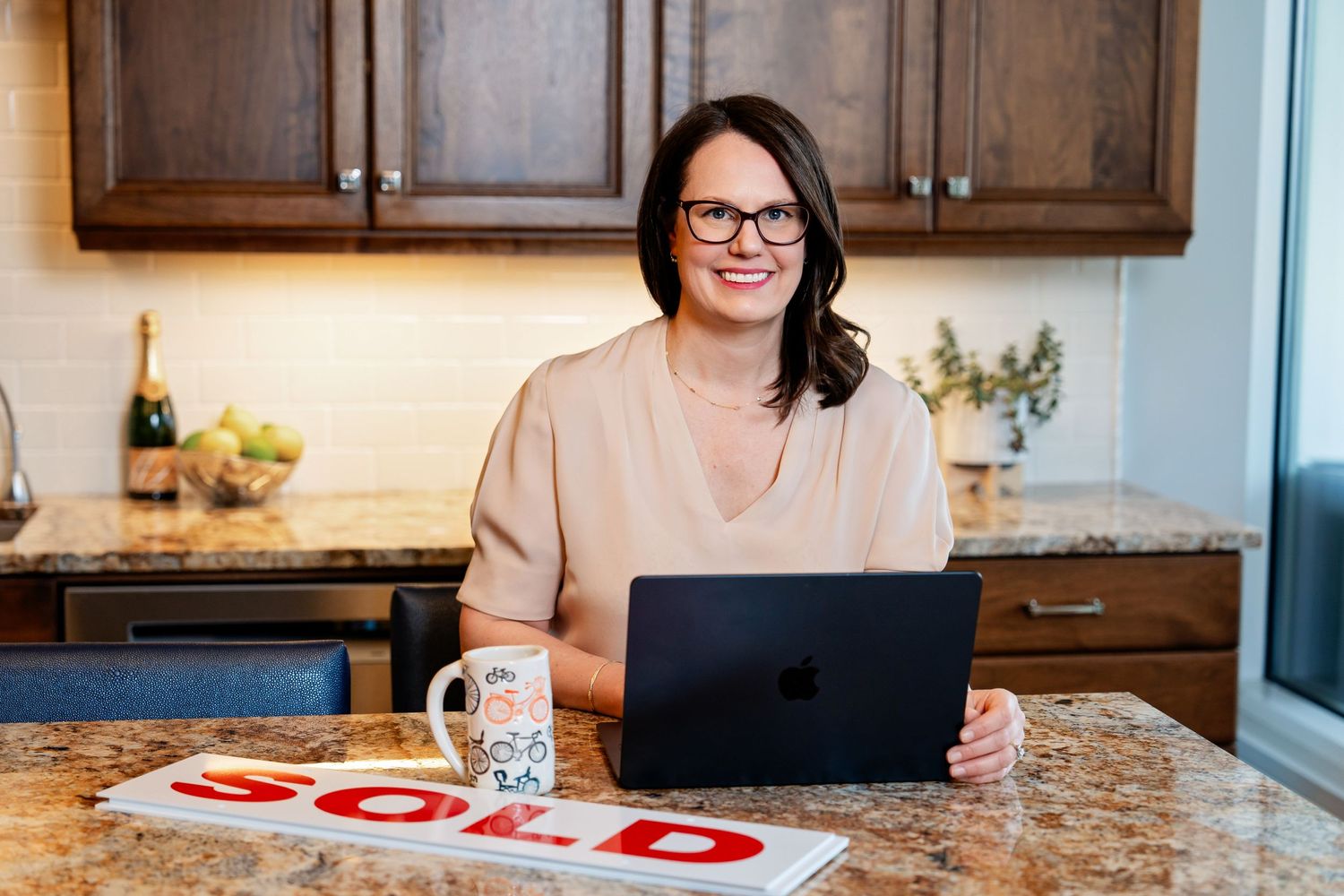 Branding photo by Milwaukee branding photographer Rachel Dickman of a female realtor with a sold sign in front of her laptop.