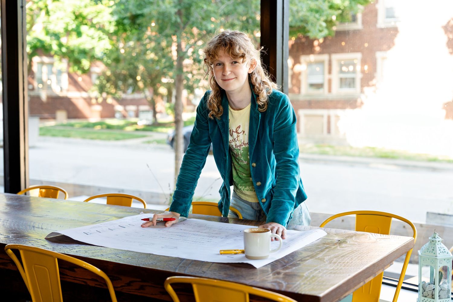 Branding photo by Milwaukee branding photographer Rachel Dickman of a young woman looking over blueprints.