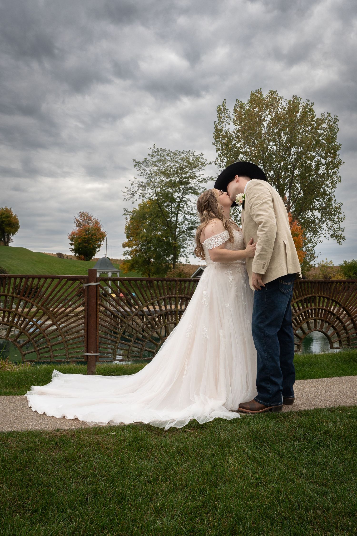 A couple sharing an intimate dance moment at their wedding, with the bride wearing a white dress and groom in camouflage vest.