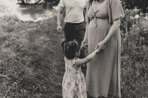 A series of vintage black and white photographs showing a family embracing in an outdoor garden setting for a maternity session.