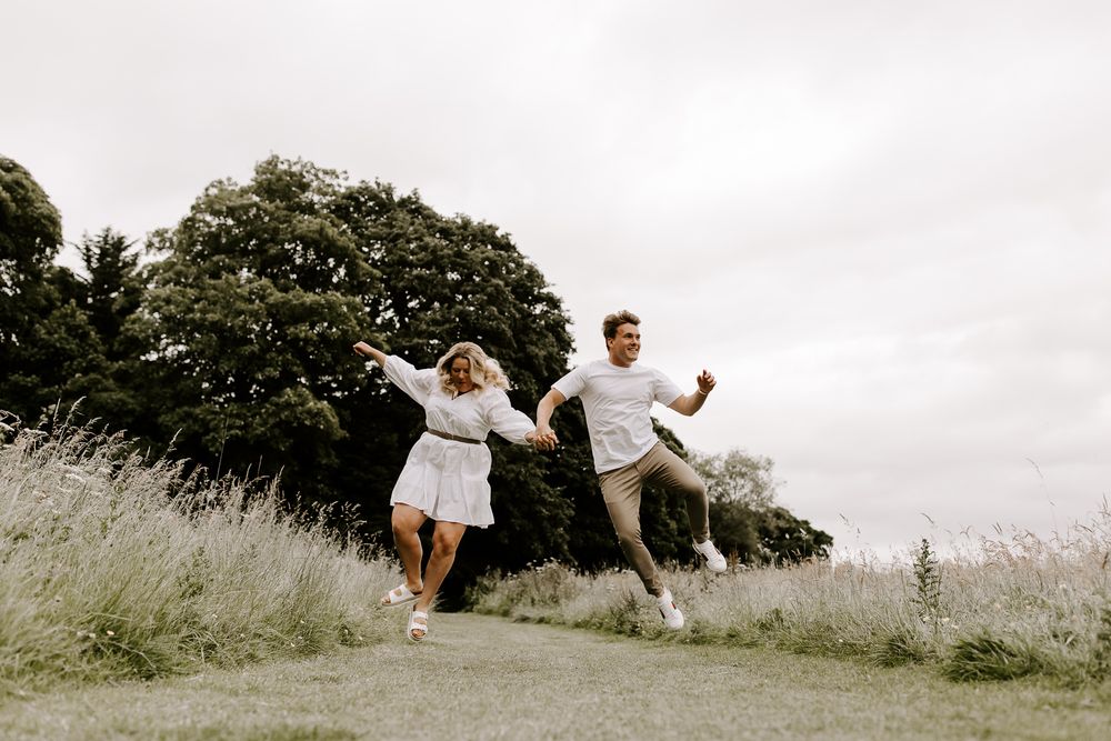 couple jumping in field