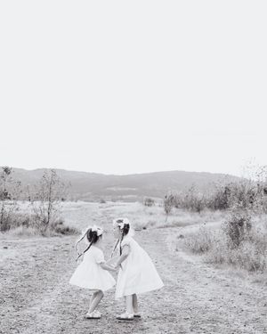 Black and white photos of two people dancing in an open field.