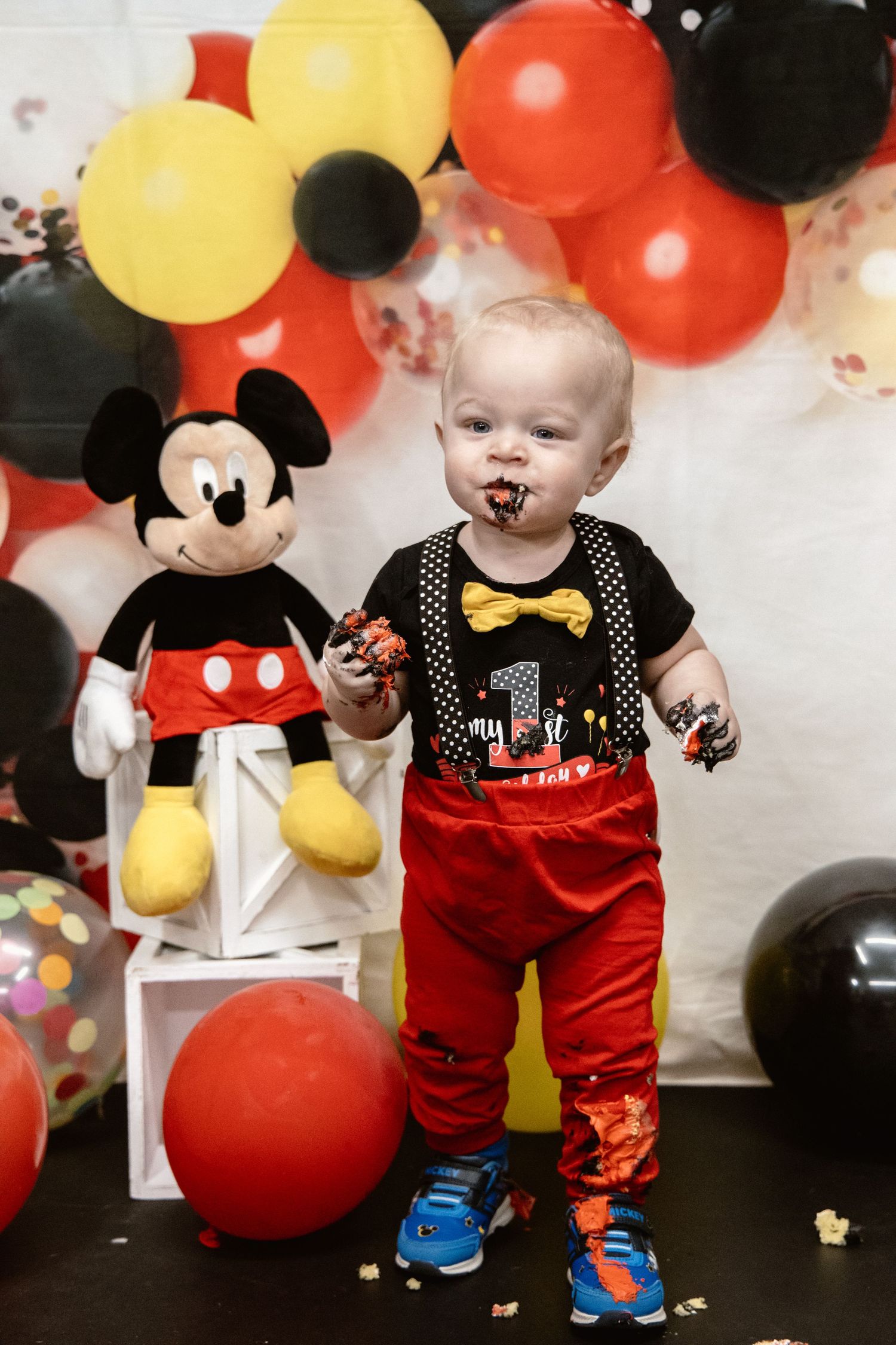 Mickey Mouse birthday party setup with red, yellow and black balloons.