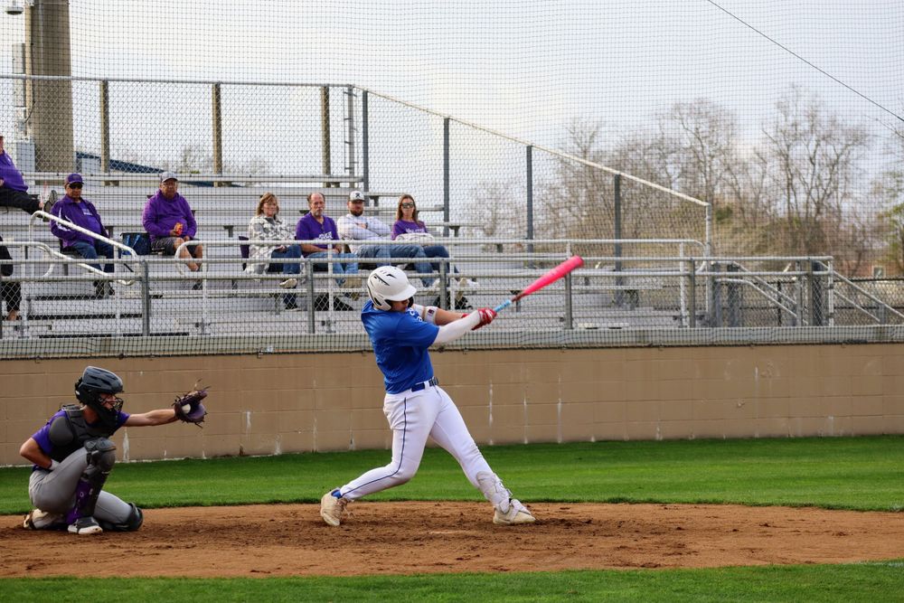 Baseball batter making contact with pitch during game.