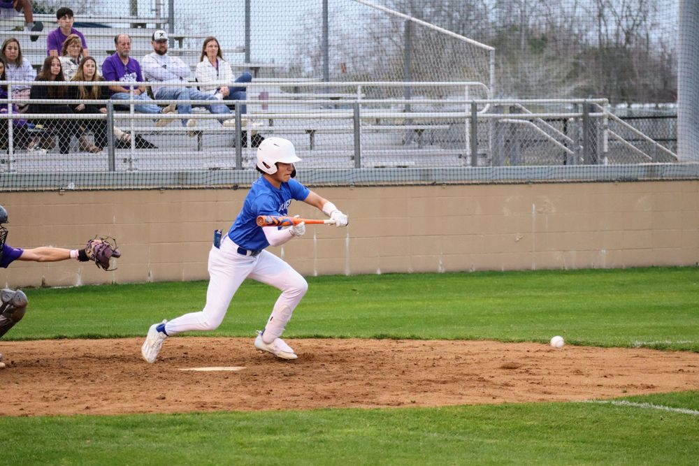 Baseball players executing sliding and base running drills during practice.