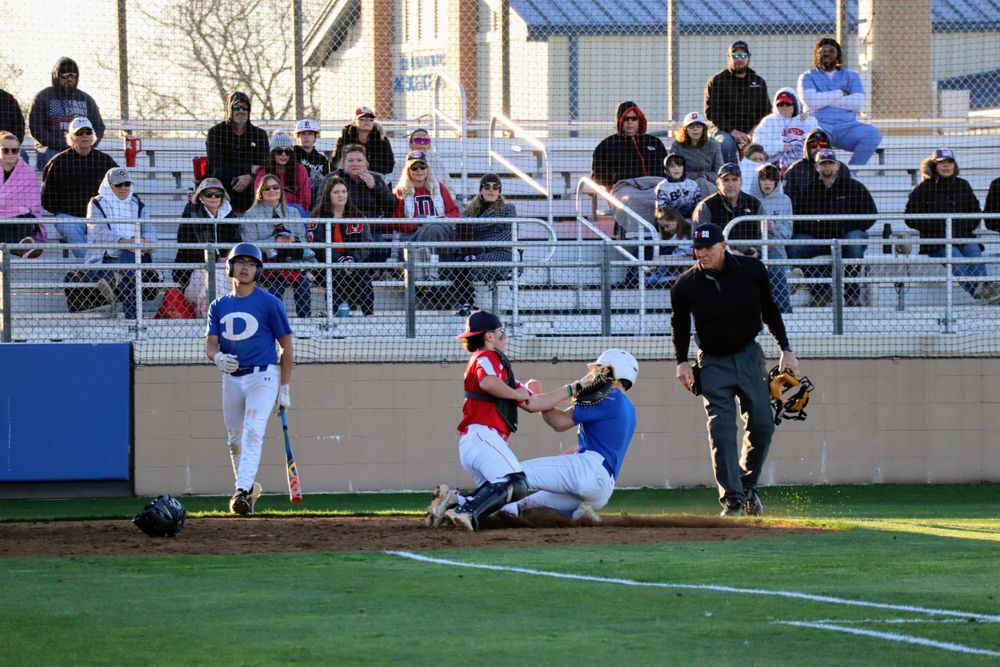 Baseball game in progress with spectators watching from bleachers.