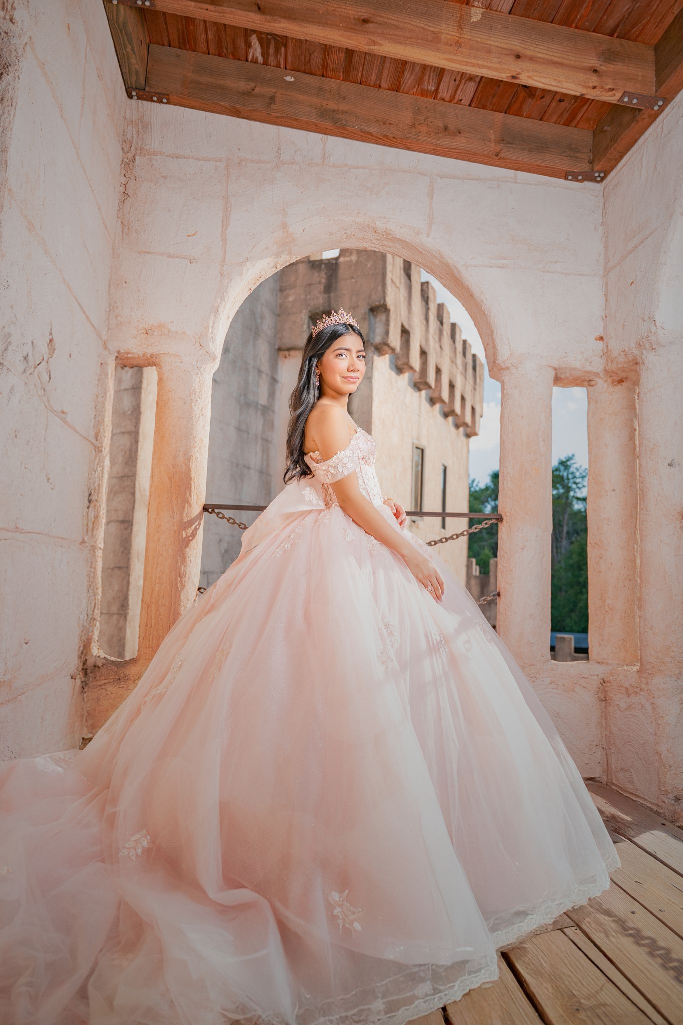 A princess-style pink and white ballgown photographed in sequence against a rustic wooden interior setting.