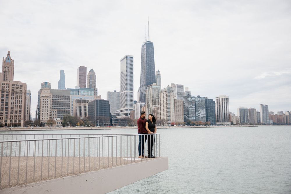 A couple enjoys the Chicago skyline view from Navy Pier on a cloudy day.