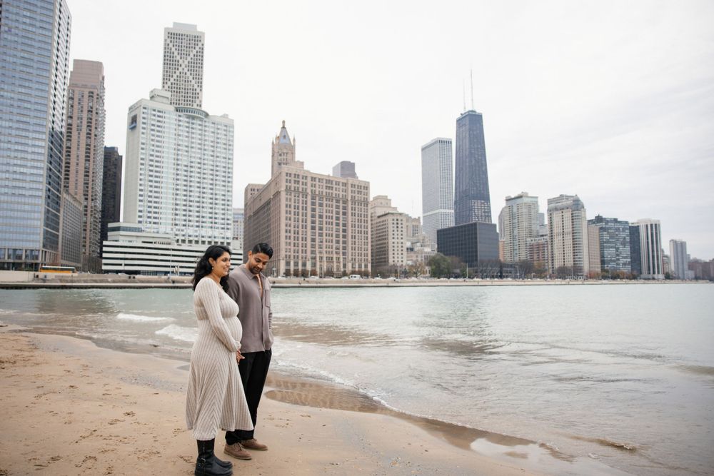 Romantic moment by Lake Michigan with downtown Chicago buildings creating dramatic backdrop.