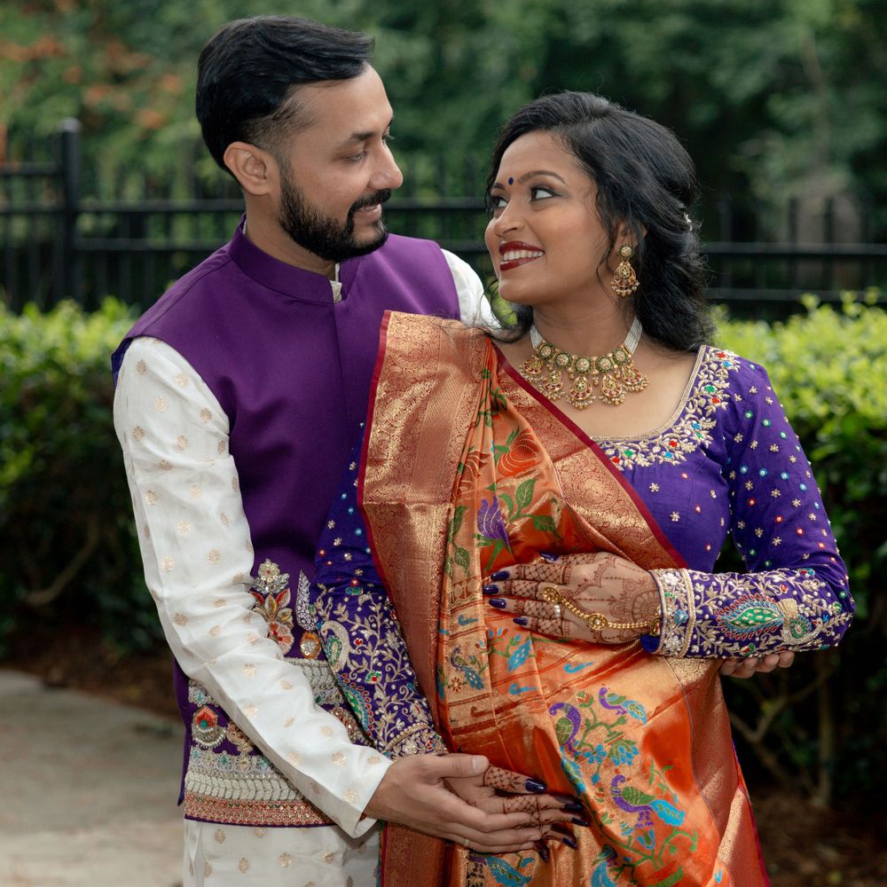 A couple in elegant Indian wedding attire poses together in a lush garden setting.