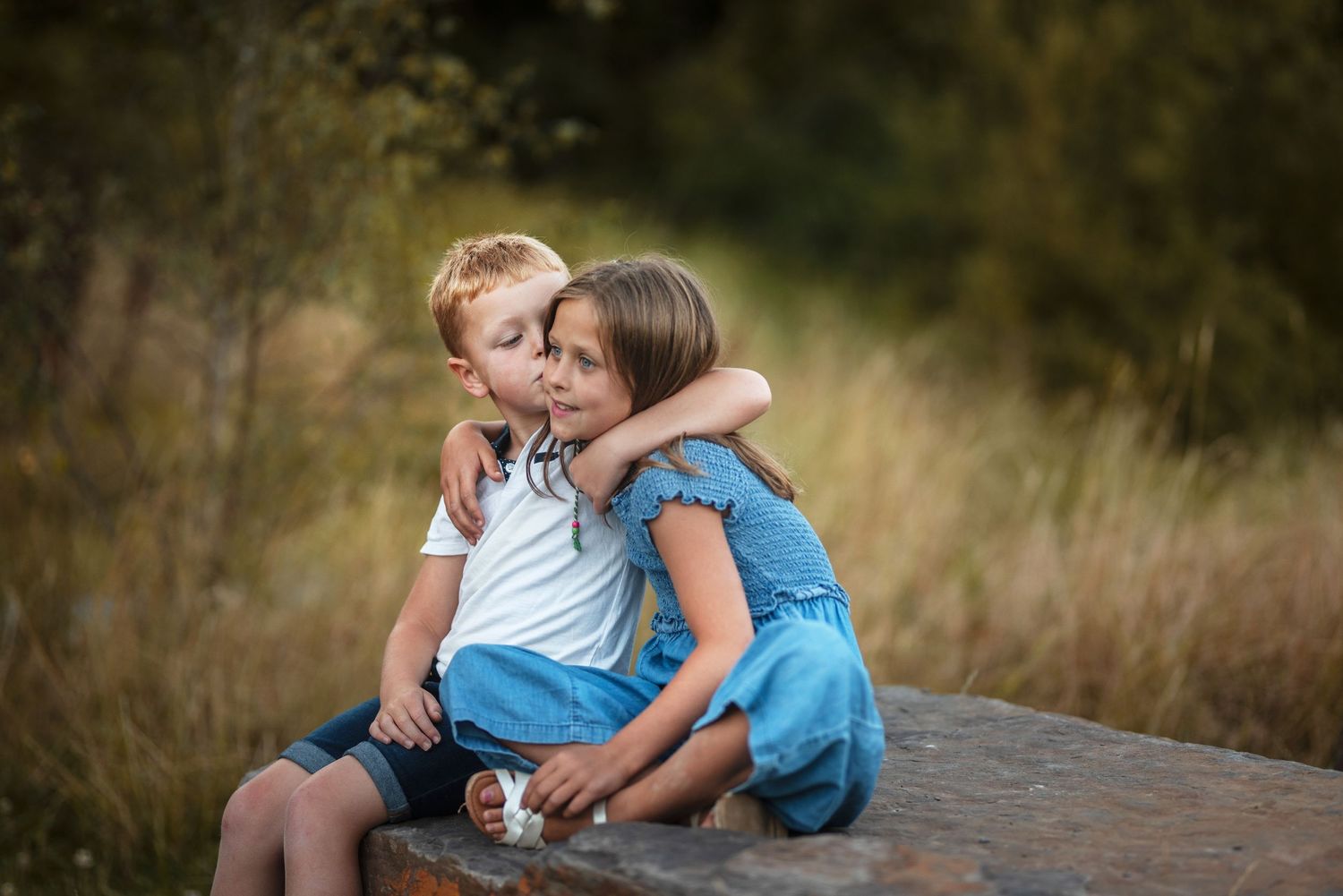 Children share tender moments with small puppies during sunset photo session.