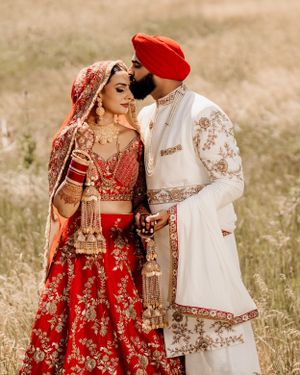Intimate portrait of newlyweds in traditional Punjabi wedding attire with intricate details.