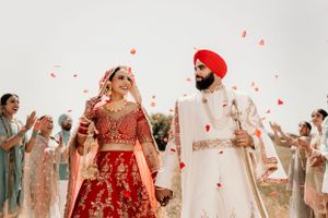 Traditional Sikh wedding ceremony with flower petals being thrown in celebration.