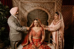 Traditional Indian wedding preparation scene with ornate decor and red bridal attire.