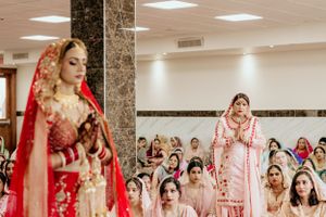 Indian wedding ceremony with attendees in traditional pink and pastel colored outfits.