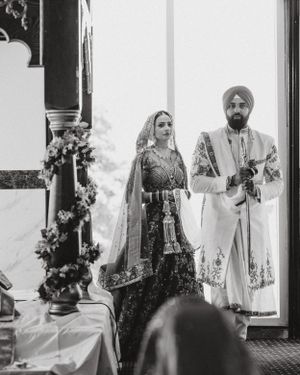 Black and white photo of traditional Sikh wedding ceremony with floral decorations.