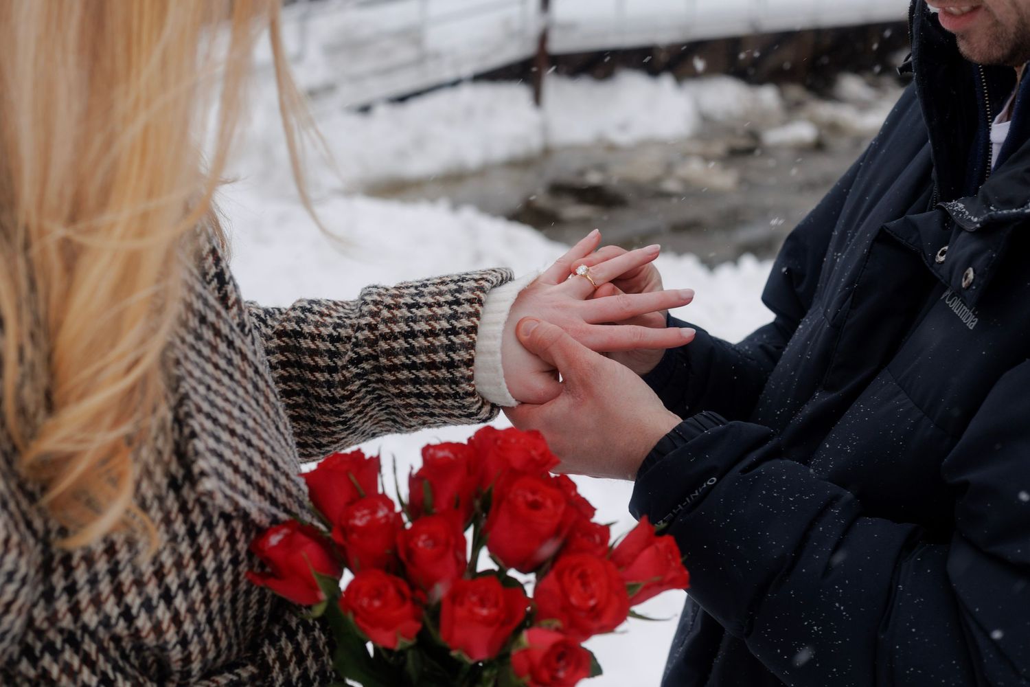 Close-up of red roses being held during a winter wedding ceremony.