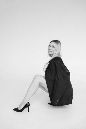 Black and white fashion portrait series showing minimalist poses against white background.