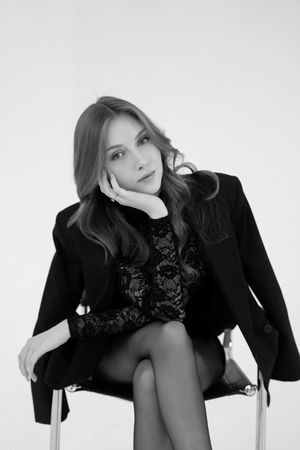 A series of black and white artistic fashion portraits showing a model in a black outfit against a white background.