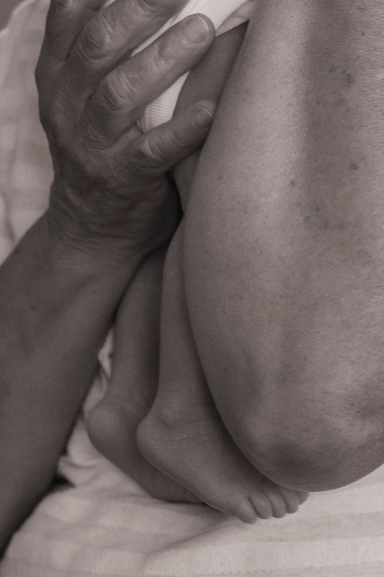 Artistic black and white close-up of newborn baby's tiny feet.