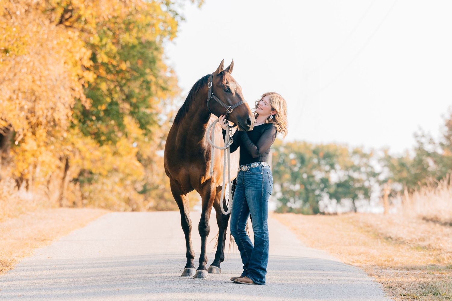 Senior posed with horse in the road